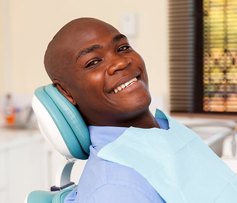 smiling man sitting in a dental chair