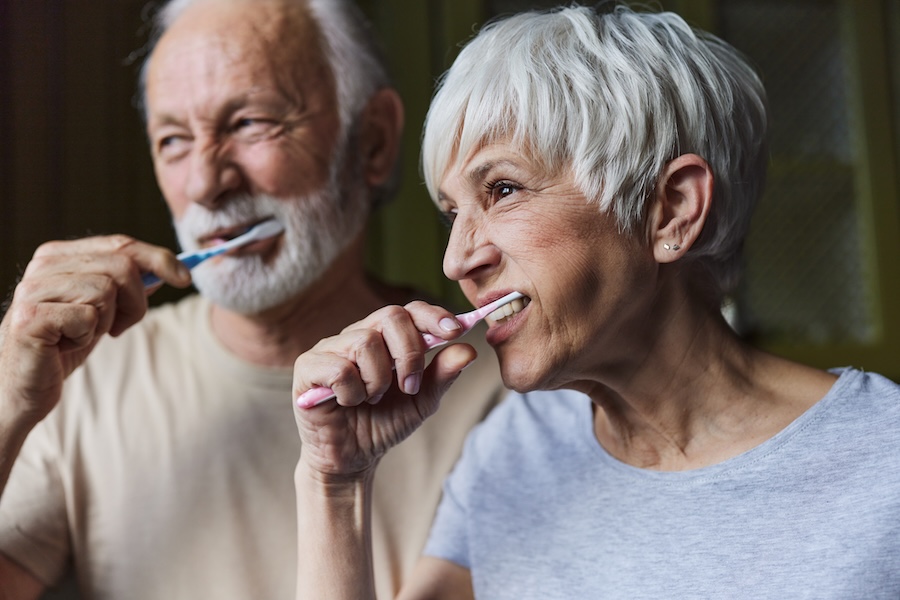 couple brushing their teeth a top way to care for your teeth between visits